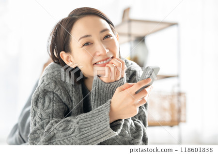 躺著，看著智能手機的女人 118601838