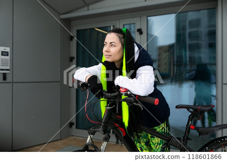 Woman in Black Jacket and Yellow Safety Vest Riding Bicycle 118601866