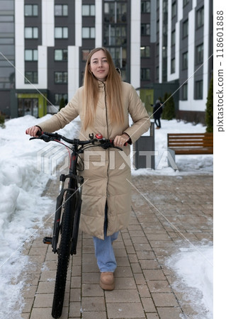 Woman Standing Next to Bike in Snow 118601888