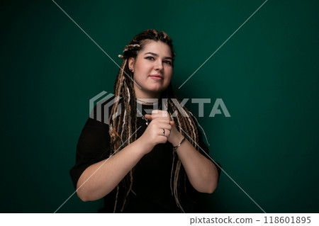 Woman With Dreadlocks Standing in Front of Green Wall 118601895