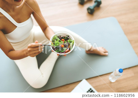 Young Asian woman holding salad bowl and looking at camera Young Asian woman holding salad bowl and looking at camera 118602956