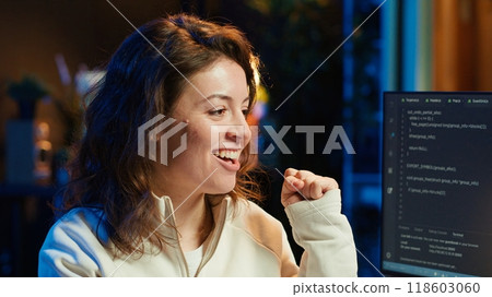 Delighted programmer celebrating after filtering malicious traffic from cybercriminals attempting to steal company data. Woman excited about accomplishment, preventing malware, camera A 118603060