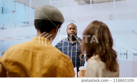 Real estate advisor discussing a promising property deal with potential corporate clients, examining blueprints and planning architectural layout of modern office space. Consider renting. Camera A. Real estate advisor discussing a promising property deal with potential corporate clients, examining blueprints and planning architectural layout of modern office space. Consider renting. Camera A. 118603109