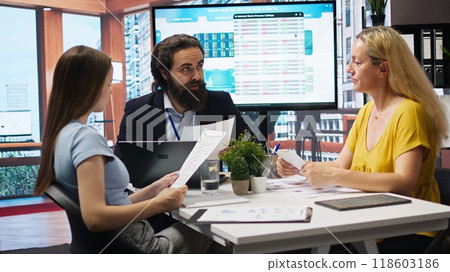 Financial adviser conducting audit of clients income, developing predictive financial models. Agent crafts customized economic strategies based on customers goals and risk tolerance, camera A Financial adviser conducting audit of clients income, developing predictive financial models. Agent crafts customized economic strategies based on customers goals and risk tolerance, camera A 118603186
