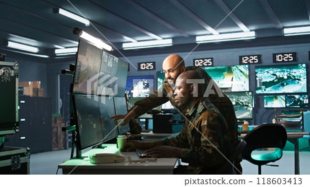 Team of army telecommunications operators using radio and satellite gear, cooperating to provide combat support. Teamworking military dispatchers colleagues managing communications networks, camera B Team of army telecommunications operators using radio and satellite gear, cooperating to provide combat support. Teamworking military dispatchers colleagues managing communications networks, camera B 118603413