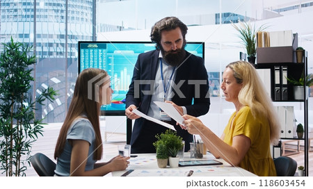 Financial adviser conducting audit of clients financial situation to strategize plan helping them reach economic goals. Agent offering advice on budgeting, investing and stock market, camera A 118603454