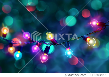 A Christmas garland with green branches, bright red and yellow lights on a string, stands out against a dark blue background, creating a vibrant and festive holiday scene 118603456