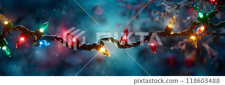 This green Christmas garland adorned with red and yellow lights glows brightly against a dark blue background, adding a cheerful and inviting touch to the festive decor, banner 118603488