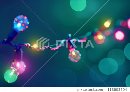 A Christmas garland with green branches, bright red and yellow lights on a string, stands out against a dark blue background, creating a vibrant and festive holiday scene 118603504