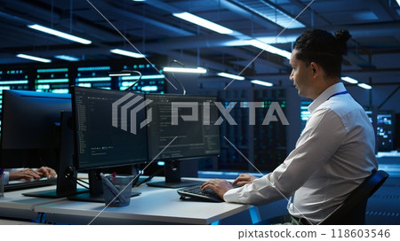 Portrait of upbeat admin in data center managing servers, operating systems and software programs. Joyous specialist in server hub ensuring networks are secure and functioning properly, camera B Portrait of upbeat admin in data center managing servers, operating systems and software programs. Joyous specialist in server hub ensuring networks are secure and functioning properly, camera B 118603546