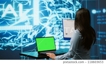 IT specialist using green screen laptop and AI technology for business data analysis in high tech setting. Engineer works on mockup notebook to automatize tasks using artificial intelligence, camera A 118603653
