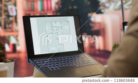 Businessman searching for commercial office spaces from his home workstation, doing a blueprints review and drafting building layouts to find the perfect startup property. Real estate. Camera A. Businessman searching for commercial office spaces from his home workstation, doing a blueprints review and drafting building layouts to find the perfect startup property. Real estate. Camera A. 118603688