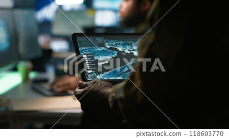Army telecommunication systems operator using satellite software on tablet, providing combat support. Military dispatcher managing communications networks, with portable device, camera A 118603770