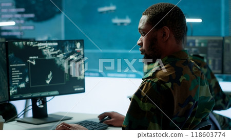 Team of military specialists overseeing surveillance activity by using a cctv footage and radar, pointing at a big screen and world map. High tech control center base of operations. Camera A. Team of military specialists overseeing surveillance activity by using a cctv footage and radar, pointing at a big screen and world map. High tech control center base of operations. Camera A. 118603774