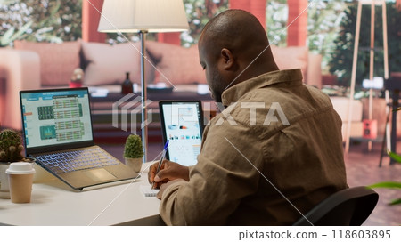 Entrepreneur conducting a data sales research with invoices and other expenses, planning a new financial investment at home office. Business analyst reviewing economy plans for growth. Camera A. 118603895