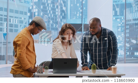 Real estate agent providing layout blueprints to clients in evaluating investment opportunity for leasing a new office space. Business team negotiating with realtor, contract agreement. Camera B. 118603900