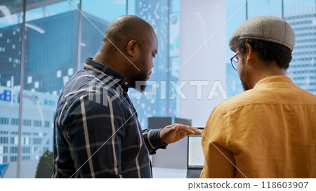 Corporate clients evaluating an investment opportunity in real estate, reviewing architectural blueprints and discussing the best strategies for office relocation and creative development. Camera A. 118603907