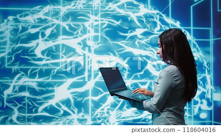 Computer scientist working on laptop, programming artificial intelligence computing simulating human brain. Woman using notebook, developing AI machine learning algorithms, camera B Computer scientist working on laptop, programming artificial intelligence computing simulating human brain. Woman using notebook, developing AI machine learning algorithms, camera B 118604016
