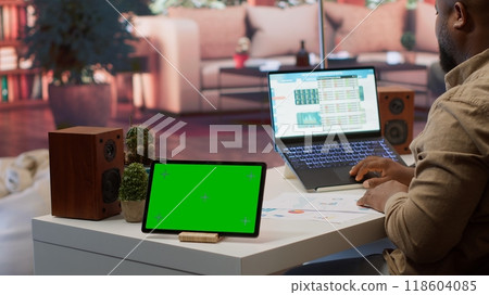 Financial expert reviews business statistics next to a chroma key screen, analyzing budget balance to ensure a correct economic situation report. Entrepreneur examines data analytics. Camera A. Financial expert reviews business statistics next to a chroma key screen, analyzing budget balance to ensure a correct economic situation report. Entrepreneur examines data analytics. Camera A. 118604085