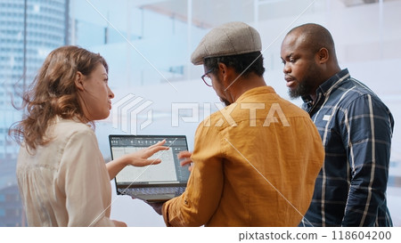 Business team evaluating architectural blueprints layout for high class office space, considering a property investment deal. Professionals negotiating with the realtor for rental agreement. Camera B. Business team evaluating architectural blueprints layout for high class office space, considering a property investment deal. Professionals negotiating with the realtor for rental agreement. Camera B. 118604200