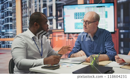 Mature couple in a detailed consultation with a financial advisor about retirement planning, covering investment strategies and savings growth. Planner with expertise offers counseling. Camera B. 118604231