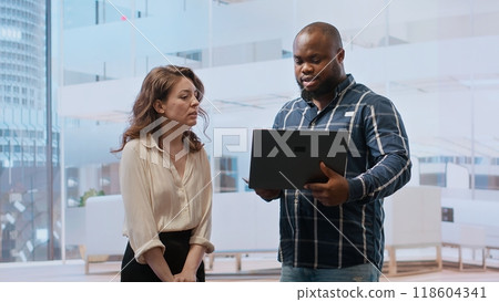 Entrepreneur meeting with a realtor salesman on an office hunt, real estate agent guiding client in order to reach leasing contract deal. Presenting modern property investment opportunity. Camera B. 118604341