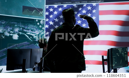 American military personnel ensuring servers protection and classified information, protecting state secrets in high tech agency office. Army soldier supervises hacking activity. Camera A. 118604351