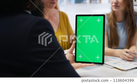 Financial adviser assisting clients in setting up investment accounts with green screen tablet, conducting audit. Consultant uses financial planning software on mockup device to help family, camera A 118604399