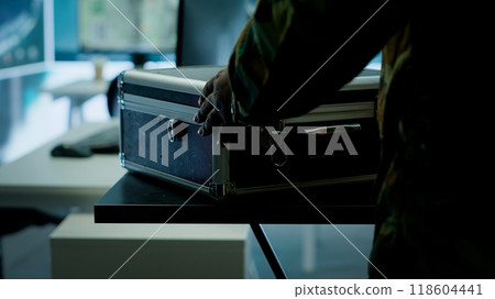 Military personnel operating in a secure office environment, processing critical information and data on big screen. Maintaining protocols essential for national defense and operations. Camera A. 118604441