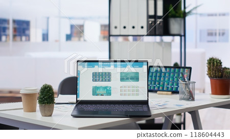 Financial analyst workspace featuring laptop and tablet displaying stock market data and statistics. Devices on desk in office next to paperwork with forex trading economic analytics figures Financial analyst workspace featuring laptop and tablet displaying stock market data and statistics. Devices on desk in office next to paperwork with forex trading economic analytics figures 118604443