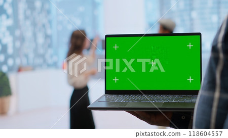 Realtors and client evaluating blueprints next to green screen display, working on new high class office space layout development. Businesswoman sharing her interior design vision. Camera B. 118604557