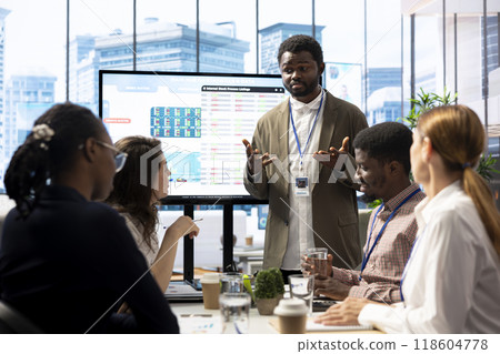 General manager sharing insight on annual infographics reports in enterprise meeting, providing initiatives to enhance operational performance metrics. Group of business associates exchange ideas. 118604778