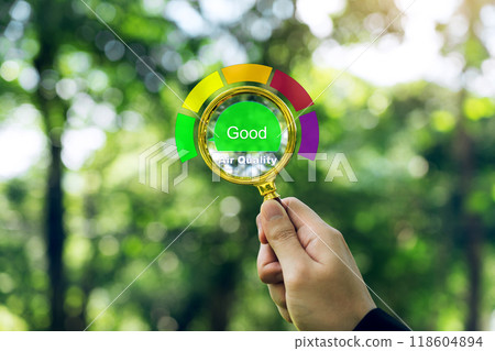 Hand holding a magnifying glass to check the good air quality and clean outdoor air quality safe. 118604894