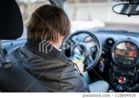 一名男子在停車時操作智慧型手機 118604916