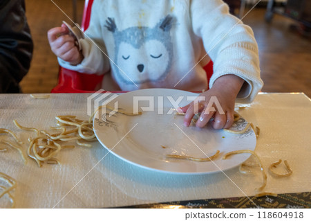 A one-year-old girl learning to eat with her hands A one-year-old girl learning to eat with her hands 118604918
