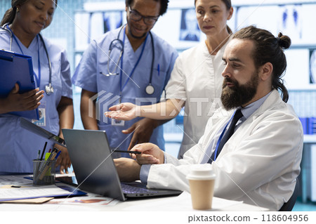 Team of medical specialists examining diagnostic data and hospital records, looking into treatment plans in a private clinic. Doctors experts coordinating recovery and discussing test results. 118604956