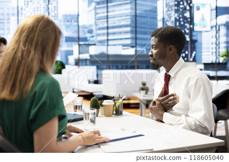 HR department expert ensuring job candidate possesses necessary qualifications fitting for company culture. Headhunter negotiating salary package and other benefits with african american man HR department expert ensuring job candidate possesses necessary qualifications fitting for company culture. Headhunter negotiating salary package and other benefits with african american man 118605040