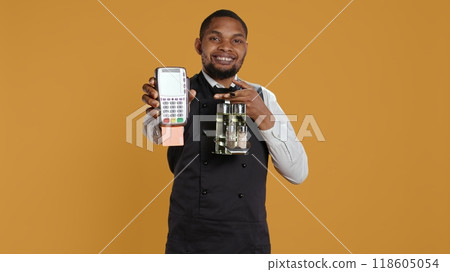 Skilled restaurant employee waiter presenting electronic payment method, showing the pos terminal with a card in it. Confident catering staff working in a customer focused environment. Camera B. Skilled restaurant employee waiter presenting electronic payment method, showing the pos terminal with a card in it. Confident catering staff working in a customer focused environment. Camera B. 118605054
