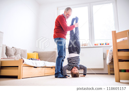 Granddad teaching boy how to make a handstand. Grandfather spending time with grandson, taking care of him while parents are at work. Having fun. 118605157