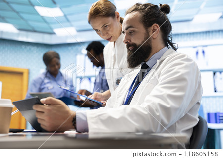 Doctors team working in a medical treatment center to find diagnosis. Professional experts engaged in a meeting about checkup test results in a private clinic, healthcare industry teamwork. 118605158