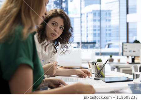 HR colleagues browsing through files, looking at CVs and doing background checks to potential job applicants. Employers in office reading resumes of candidates for vacant startup business position HR colleagues browsing through files, looking at CVs and doing background checks to potential job applicants. Employers in office reading resumes of candidates for vacant startup business position 118605235