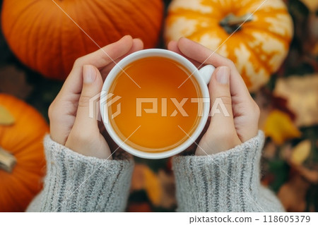 Hands holding cup of tea and pumpkin. Generative AI. 118605379