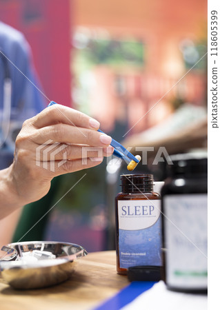 Professional nurse separating pills and medicine in two different bottles, preparing the weekly treatment with daily doses for senior man and woman. Caretaker offer health aid to patients. Close up. 118605399