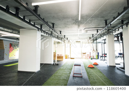 Gym with equipment, metal barbells, dubbells on racks for strength training. 118605400