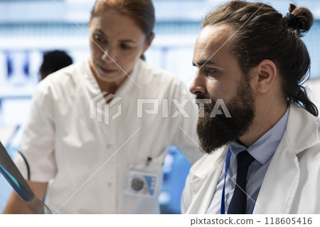 Medical experts analyzing x ray results and discuss treatment options. Team of licensed healthcare specialists working together to provide accurate diagnosis and effective recovery in a clinic. Medical experts analyzing x ray results and discuss treatment options. Team of licensed healthcare specialists working together to provide accurate diagnosis and effective recovery in a clinic. 118605416