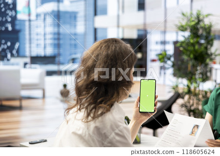 HR expert discussing with woman, vetting applicants to ensure skills match role needs, using mockup mobile phone. Headhunter chatting with person coming for interview, using chroma key smartphone 118605624