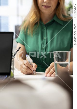 Person writing with pen on contract papers after qualifications aligned with company expectations. Close up of applicant filling application form files after making recruiter happy with resume 118605647