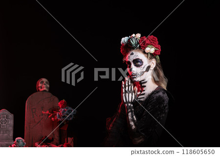 Woman celebrating Day of the Dead Mexican holiday honoring dead loved ones to return for family reunion after building altar for them. Lady doing ancient Aztec custom of celebrating ancestors Woman celebrating Day of the Dead Mexican holiday honoring dead loved ones to return for family reunion after building altar for them. Lady doing ancient Aztec custom of celebrating ancestors 118605650