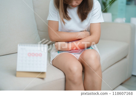 Menstruation period cycle of monthly and Stomachache concepts. woman having abdomen pain with hot water bottle and calendar, illness female suffer from premenstrual ache and body Health problem 118607168