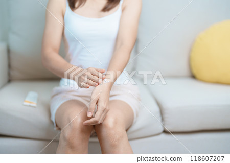 Arthritis and Muscle Pain Relief Cream concept. Woman having wrist pain at home, muscle ache due to De Quervain s tenosynovitis, ergonomic, Carpal Tunnel Syndrome or Office syndrome and Parkinson 118607207